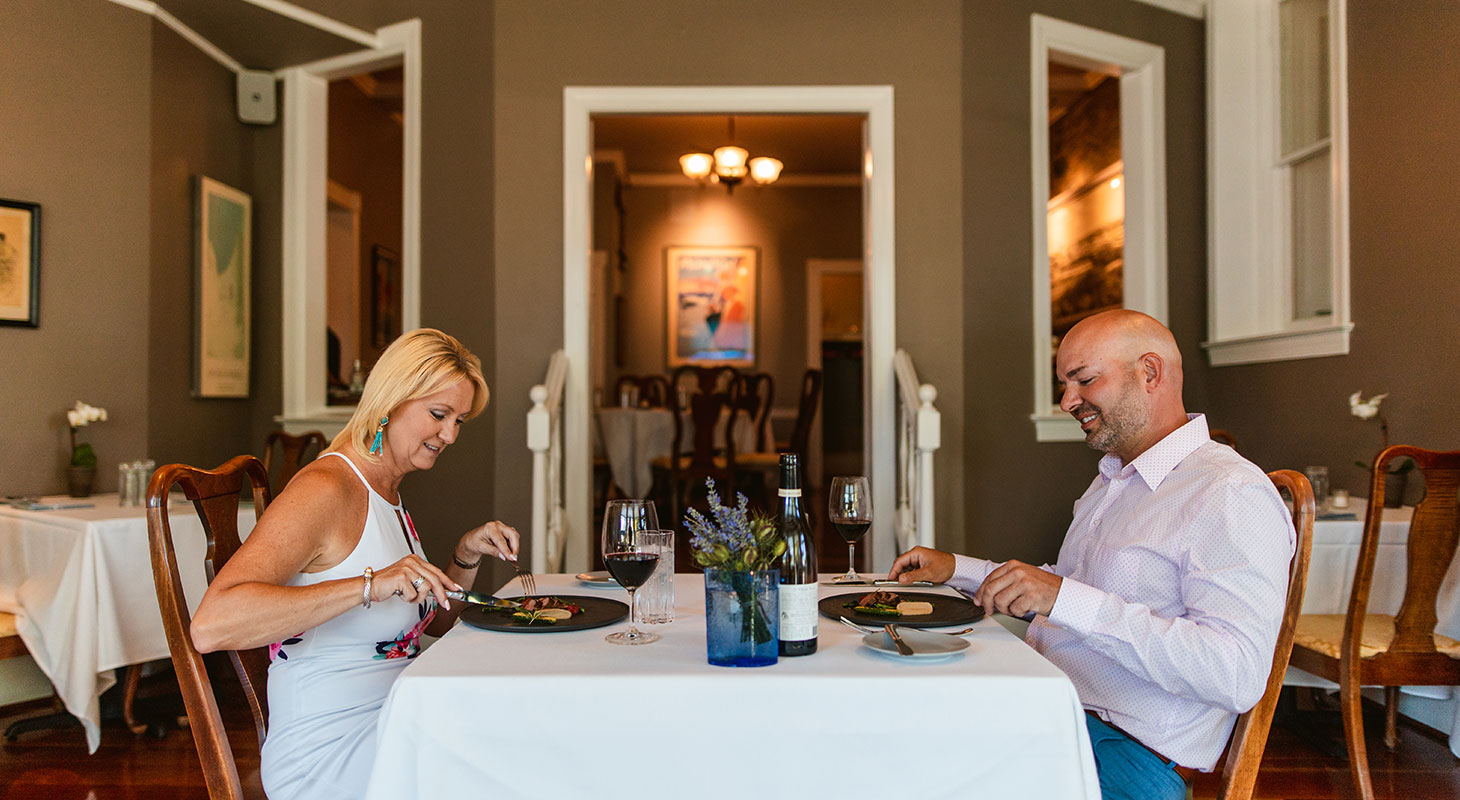 Couple with entrees and wine at La Table Provencale