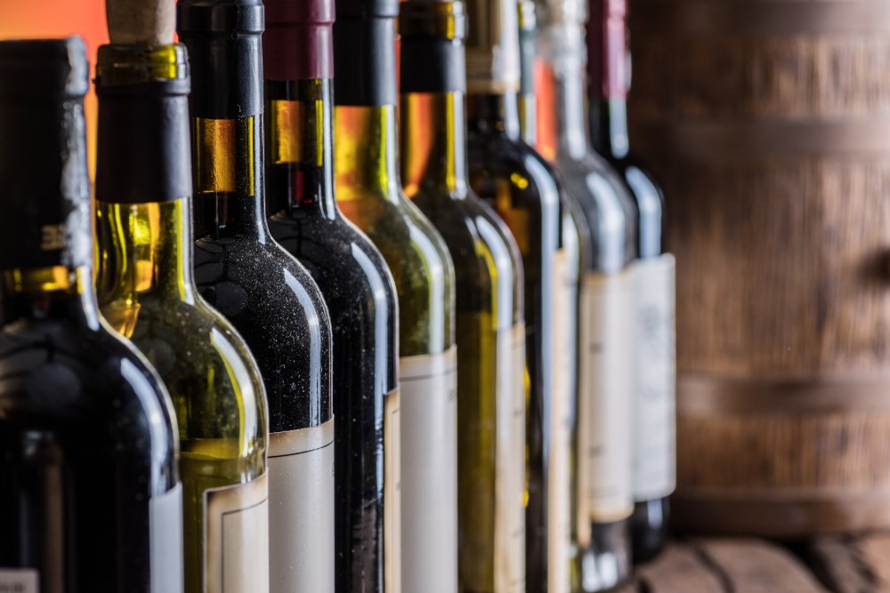 wine bottles in front of oak barrel