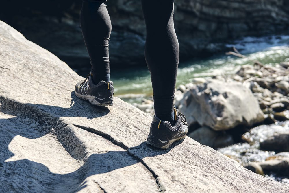a woman standing above a rocky stream