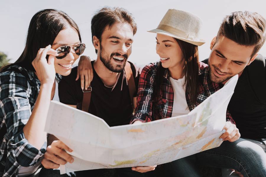Group of friends looking at a paper map on a road trip